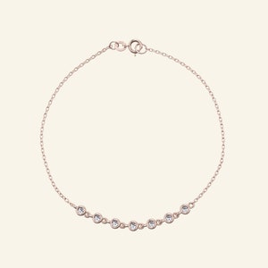 Pu&ograve; includere: Bracciale in oro rosa con una catena sottile e una serie di pietre preziose rotonde e trasparenti. Le pietre sono distanziate lungo il bracciale, creando una sottile lucentezza. Chiusura semplice.