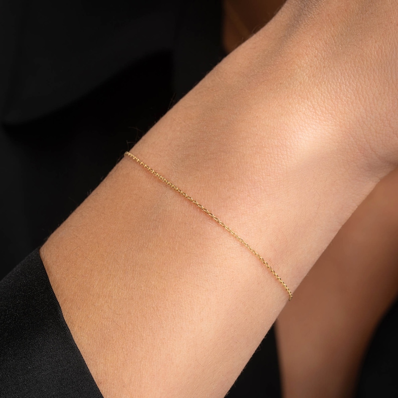 May include: A delicate gold chain bracelet