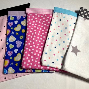 May include: Six fabric pouches with different patterns. The pouches are pink with black polka dots, blue with colourful hearts, pink with white polka dots, white with colourful polka dots, white with grey stars, and grey with white polka dots.