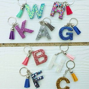 Crafty Angel Art F - Letter - Initial Resin Keychain Translucent Letter F with Sea Shells Inside It and Purple Party Glitter on The Front with A Beaded Charm and A Paw