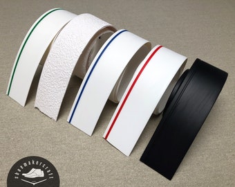 May include: A selection of shoe sole edging strips in different colours. Includes white strips with green, blue, and red accent lines, a textured white strip, and a black strip. The shoemaker's logo is visible.