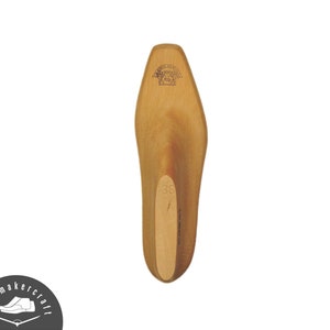 Può includere: Forma per scarpe in legno chiaro, di colore marrone chiaro, con finitura liscia. La forma è contrassegnata dal numero "38" e da un logo in alto. Il logo Shoemaker Craft è visibile in basso a sinistra.