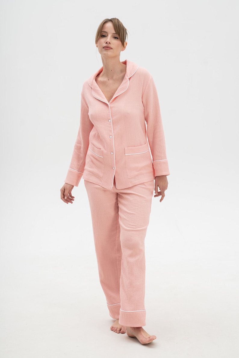 Peut inclure: Un ensemble pyjama rose &agrave; manches longues avec des bordures blanches. Le haut a un devant boutonn&eacute; et un col. Le pantalon a une jambe droite.