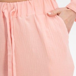 Peut inclure: Un pantalon rose clair avec une taille &agrave; cordon et un tissu textur&eacute;.