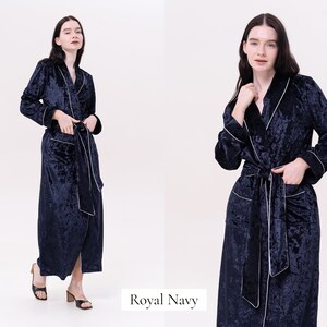 May include: A navy blue velvet robe with white piping. The robe has a shawl collar, a tie belt, and two pockets.