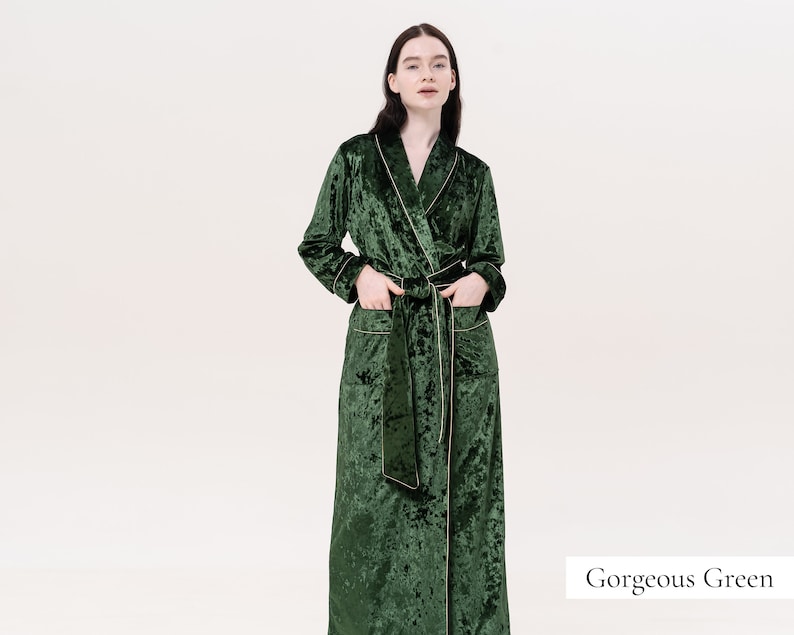 May include: A long, dark green velvet robe with a shawl collar and a self-tie sash. The robe has a subtle shimmer and a slightly textured surface. The text "Gorgeous Green" is visible in the lower right corner of the image.