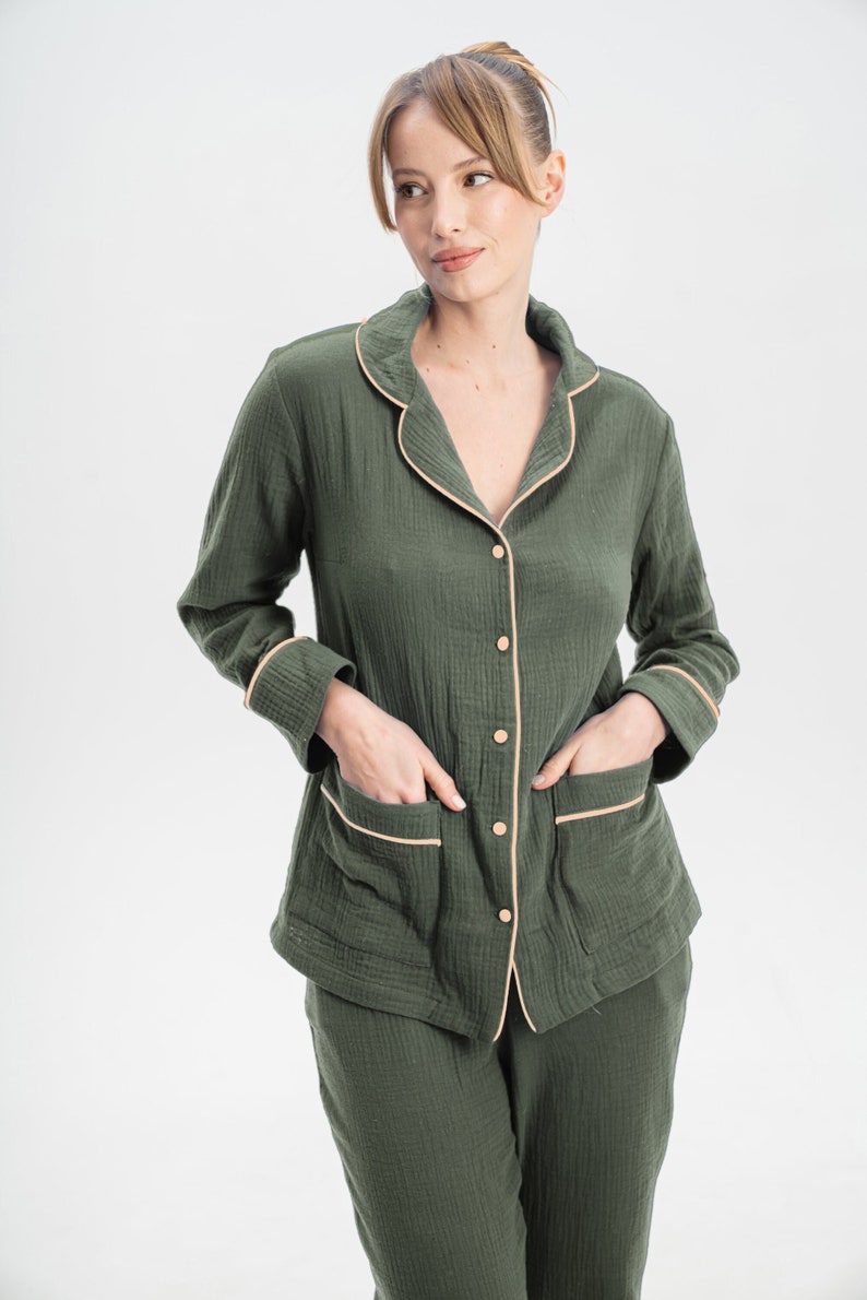 Peut inclure: Un haut de pyjama boutonn&eacute; vert avec une bordure cr&egrave;me et un pantalon assorti. Le haut a des manches longues et deux poches.