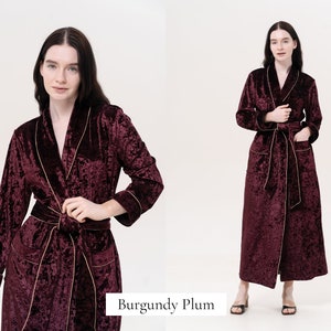 May include: A long, burgundy velvet robe with gold piping. The robe has a shawl collar, a tie belt, and two pockets.