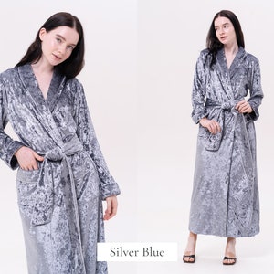 May include: A silver blue velvet robe with a shawl collar and a tie belt. The robe has a textured, crushed velvet look.