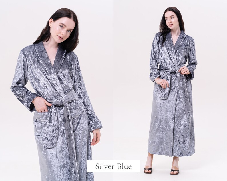 May include: A silver blue velvet robe with a shawl collar and a tie belt. The robe has a textured, crushed velvet look.