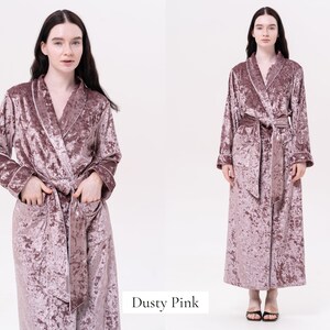 May include: A dusty pink velvet robe with a shawl collar and a tie belt. The robe has long sleeves and pockets.