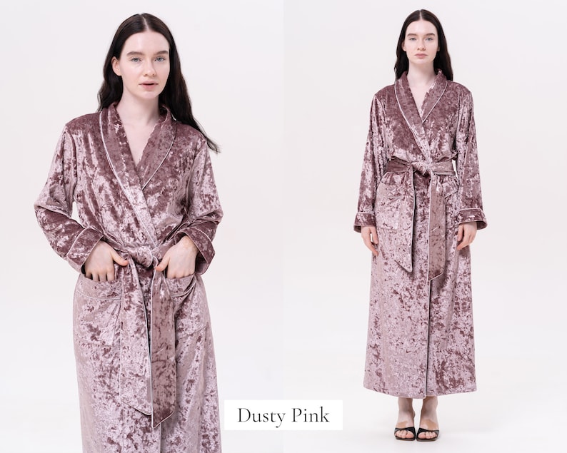 May include: A dusty pink velvet robe with a shawl collar and a tie belt. The robe has long sleeves and pockets.