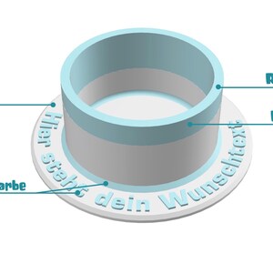 May include: A white ring with a blue ring on top. The text "Hier steht dein Wunschtext" is printed on the white ring. The blue ring has a customizable height and color.