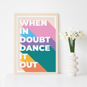 May include: A framed print with a colourful geometric design and the text "WHEN IN DOUBT DANCE IT OUT".