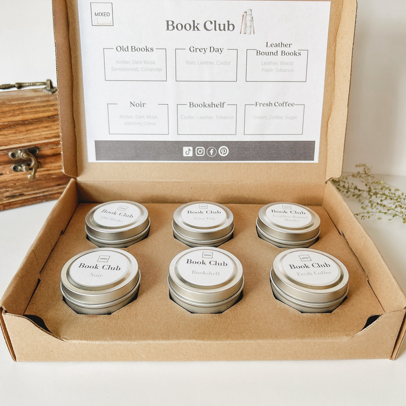 Six mini candles in their own compartments of a cardboard box. The scents are Old Books, Grey Day, Leather Bound Books, Noir, Bookshelf, and Fresh Coffee.