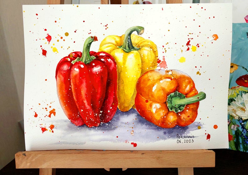 May include: Watercolor painting of three bell peppers, one red, one yellow, and one orange, on a white background with colorful splatters. The painting is signed "Pokamis 06.2023".