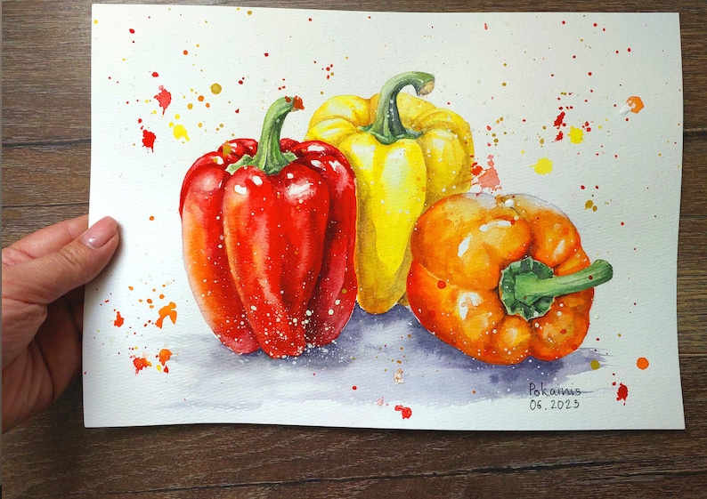 May include: Watercolor painting of three bell peppers, one red, one yellow, and one orange. The peppers are arranged in a still life composition on a white background with splattered paint.
