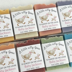 Puede incluir: Varias pastillas de jab&oacute;n de colores, cada una con una etiqueta con un ganso de dibujos animados y el texto "A little silly Goose". Las etiquetas tambi&eacute;n incluyen el texto "Baby Jackson DUE APRIL 2026."