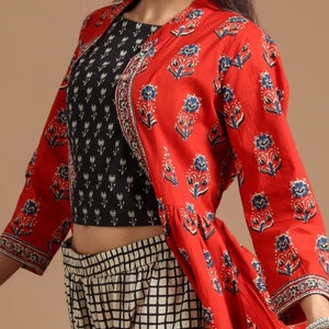 May include: A red and blue floral print long-sleeved jacket with a black and white floral print top and a black and white checkered palazzo pant.