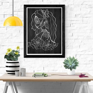 K&ouml;nnte beinhalten: Schwarz-wei&szlig;-Linienkunst-Druck einer Frau mit floralem Design. Die Frau hat ein Zucker Sch&auml;del Gesicht und einen Schmetterling im Haar. Der Druck ist in einem schwarzen Rahmen gerahmt und h&auml;ngt an einer wei&szlig;en Backsteinwand.