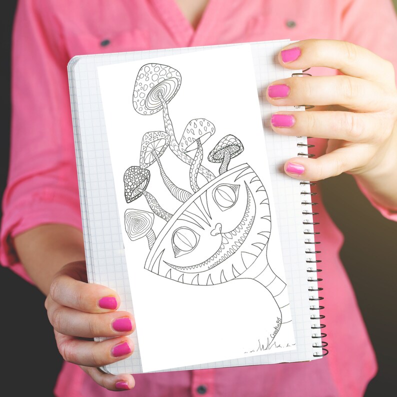 May include: A black and white illustration of the Cheshire Cat from Alice in Wonderland with mushrooms. The drawing is held in a spiral-bound notebook. The cat's grin and the mushrooms are detailed with intricate patterns.