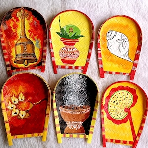 May include: Six hand-painted, decorative trays with a woven bamboo base. Each tray features a unique design, including a bell, a pot with leaves, a conch shell, oil lamps, a bowl with smoke, and a fan. The trays are painted with vibrant colors.