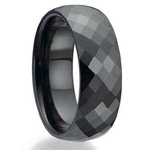 May include: A black ceramic ring with a faceted, diamond-like design.