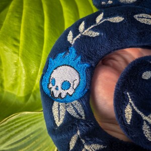 Op de afbeelding: Donkerblauwe pluche hoofdband met geborduurde zilveren bladeren en een blauw vlammenontwerp met een witte schedel. De hoofdband is zacht en pluche, perfect voor cosplay of dagelijks gebruik.