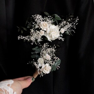 Matching white and eucalyptus pocket boutonnieres for groom and groomsmen.