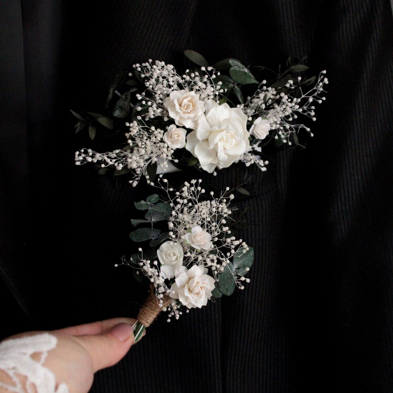 Matching white and eucalyptus pocket boutonnieres for groom and groomsmen.