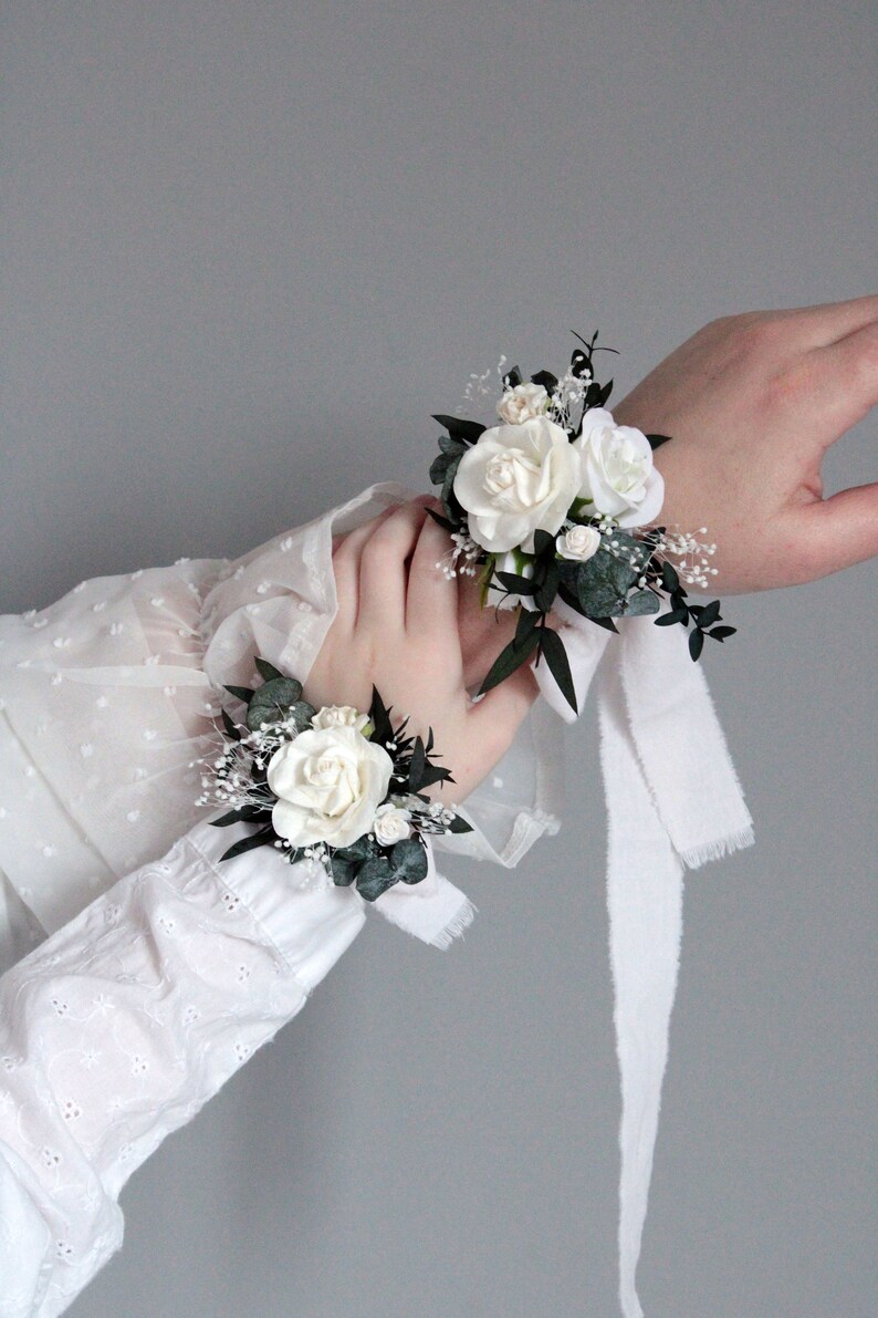 White floral wrist corsage for bridesmaid, matching wedding set with boutonniere.