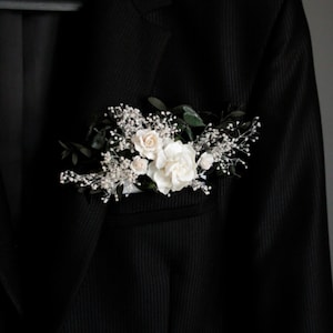 Large white floral pocket boutonniere with eucalyptus leaves, modern groom accessory.