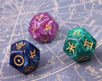 May include: Three iridescent dice with gold zodiac symbols. The dice are purple, blue, and green. The symbols on the dice are Pisces, Aquarius, and Capricorn.