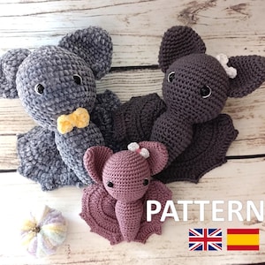 Puede incluir: Tres peluches de murciélago de ganchillo en gris y malva, con una pequeña pajarita amarilla y lazos blancos. La palabra "PATTERN" se muestra en texto blanco. Los murciélagos tienen orejas y alas grandes, y están colocados sobre una superficie de madera.