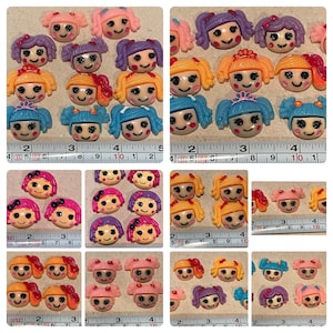 May include: Assortment of colorful, handmade polymer clay buttons featuring cartoon faces with various hairstyles and expressions. The buttons are approximately 1 inch in diameter.