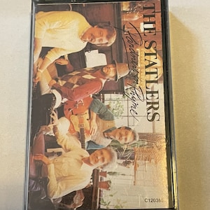 May include: A cassette tape featuring a photo of The Statlers band members. The album cover is titled "Hand Me Down Your Love". The cassette tape is black with a clear plastic case.