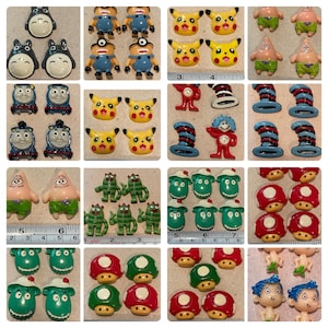 Op de afbeelding: Assortiment van kleurrijke cartoon-personageknoppen, waaronder Totoro, Pikachu, Mario en de Kat in de Hoed. De knoppen zijn gemaakt van plastic en hebben een platte achterkant.
