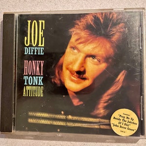 May include: A CD case with a photo of Joe Diffie, a country music singer, on the front. The title of the album is "Honky Tonk Attitude".