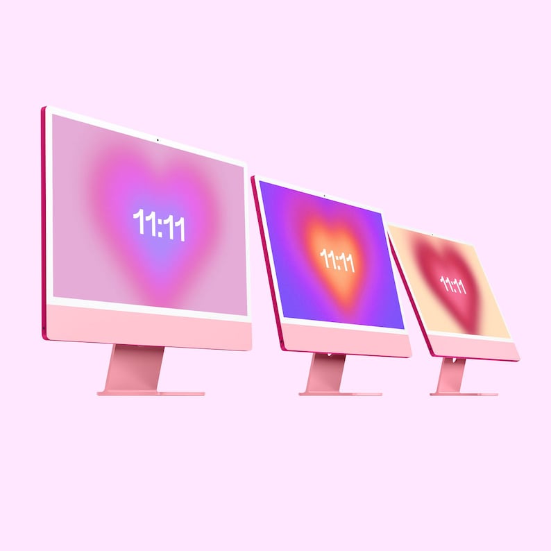 May include: Three pink desktop computers with white screens displaying a gradient background with a heart shape and the text "11:11" in white.