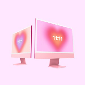 May include: Two pink desktop computers with white screens displaying a pink heart with the number 11:11 in white text.