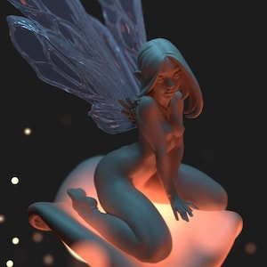 Puede incluir: Una escultura de una hada desnuda con alas translúcidas, posada sobre una flor estilizada y brillante. El hada tiene pelo largo y está sentada. El fondo es oscuro con partículas brillantes dispersas.