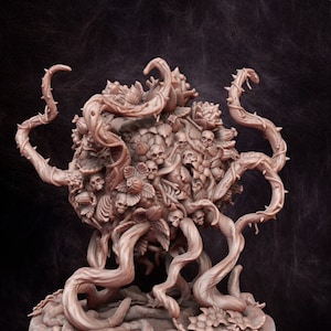 May include: A detailed, brown miniature sculpture of a grotesque, plant-like creature. The sculpture features a central mass of skulls and foliage, with thorny vines extending outwards. The base is circular, and the overall design is intricate and detailed.
