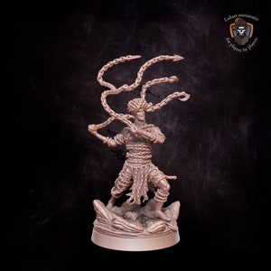 May include: A miniature figurine of a warrior, intricately detailed and wrapped in chains. The figure is posed dynamically, wielding chains with bladed ends. The base is a textured, rocky terrain. The figurine is a light brown color.