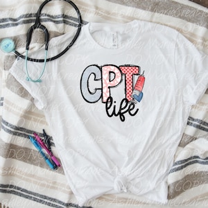 May include: A white short-sleeved t-shirt featuring the text CPT life in a stylized font. The letters C, P, and T are filled with blue, pink, and red patterns, and a syringe graphic replaces the letter I. A black stethoscope and two pens are visible.