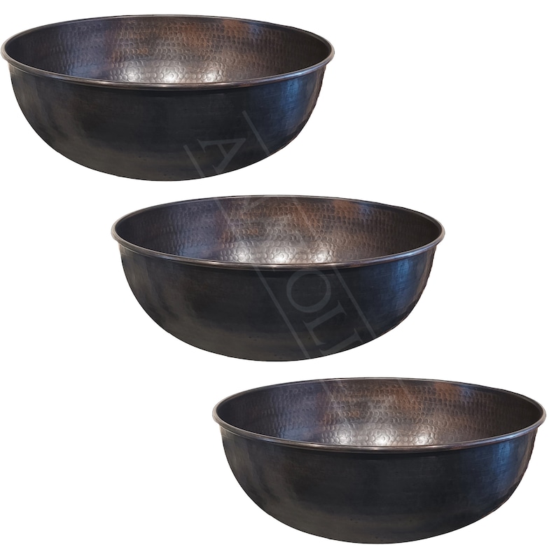 May include: Three hammered copper bowls, each with a slightly different shade of brown, are arranged in a pyramid shape. The bowls are all round and have a smooth, polished finish.