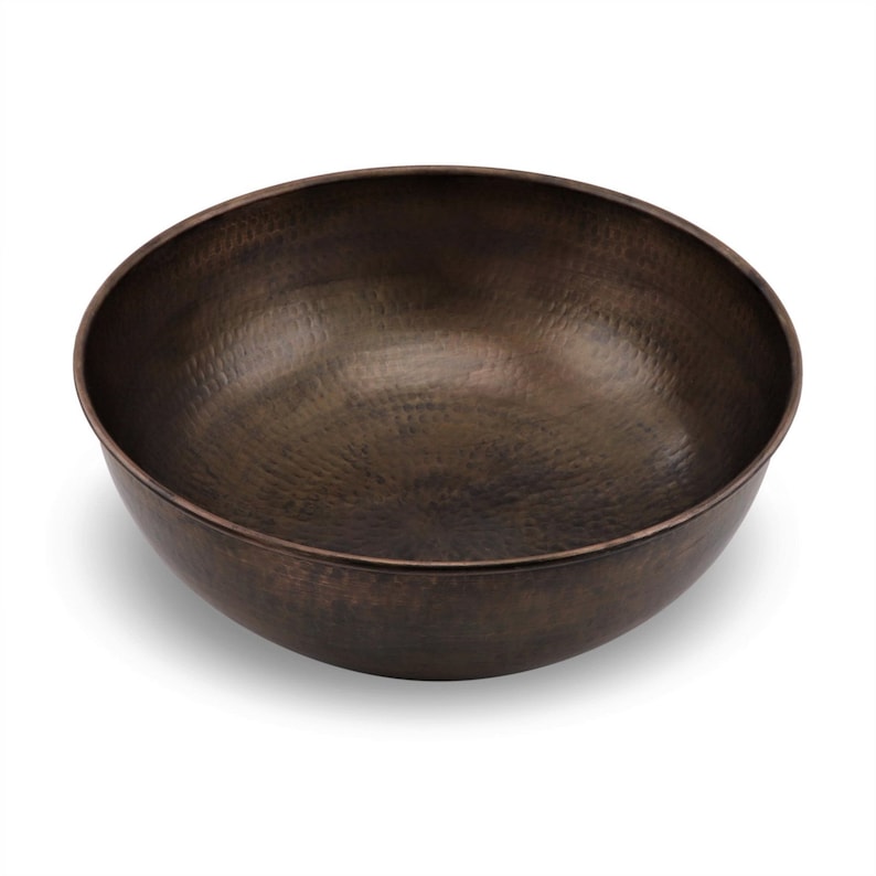 May include: A large, round, hammered copper bowl with a dark brown patina. The bowl is empty and has a slightly textured surface.