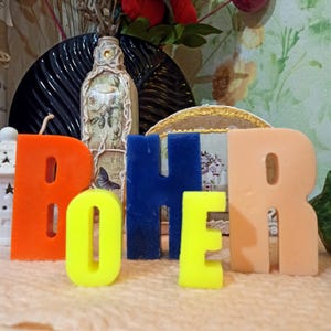 Different color and size candle letters in decor.
