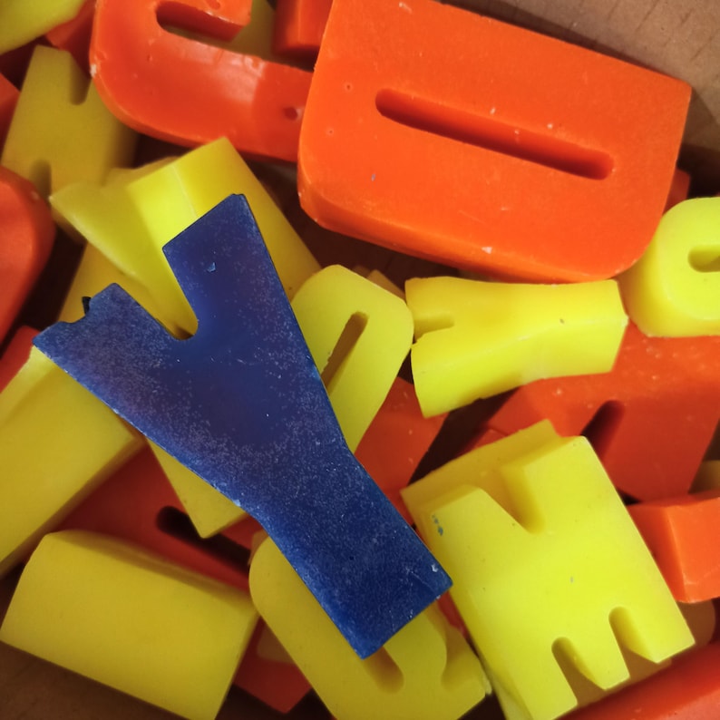 Different color and size candle letters in a box.