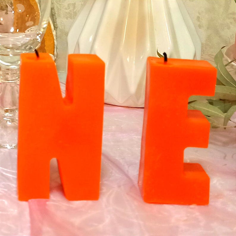 Two orange letters N and E close-up.