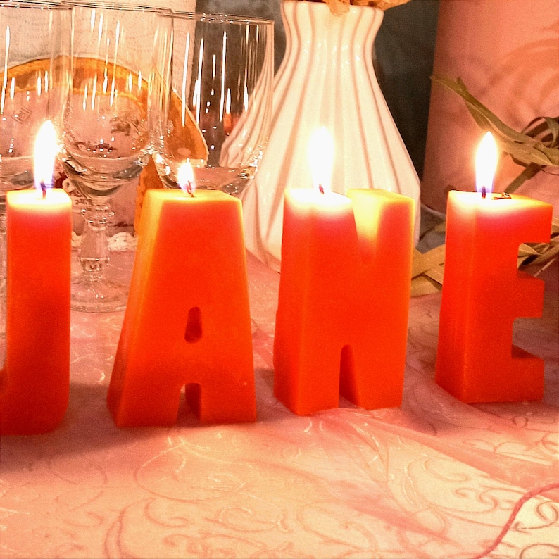 lit orange letters candles in decor.
